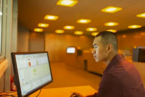 Engineer working at computer in factory control room 스톡 사진