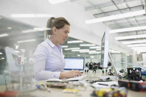 Engineer working at computer with robotics Stock Photos