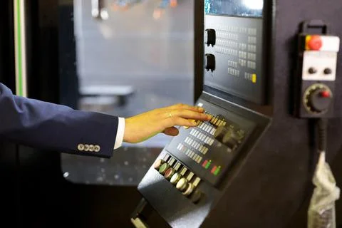 Engineer working with control panel of CNC machine Stock Photos