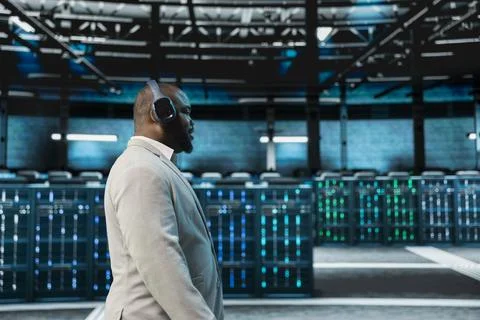 Engineer working in data center, listening music and overseeing infrastructure Stock Photos