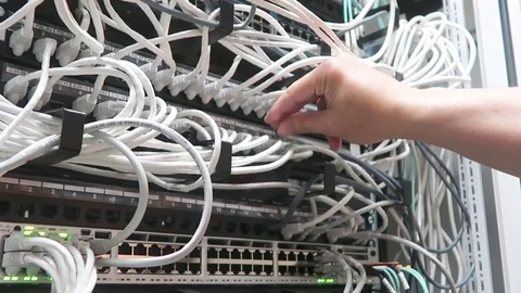 Engineer working in a data center with rows of server racks and super computers. Stock Footage 90000225
