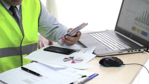 Engineer working at desk, examining reports. Stock-Footage 75423711