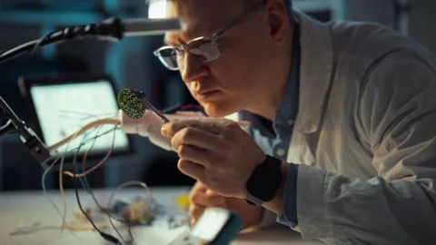 Engineer working diligently on circuit board assembly in a modern lab settin Stock Footage 323765697