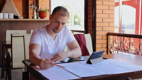 Engineer working with drawings and documents in a cafe Stock Footage 95938353