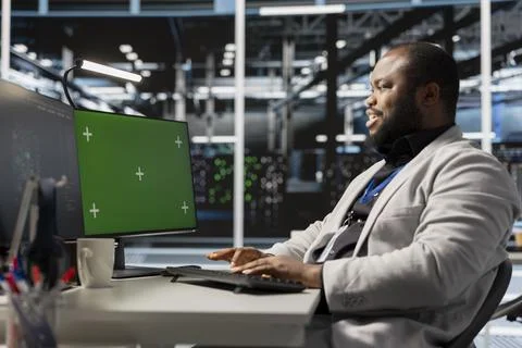 Engineer working on green screen desktop PC in data center Foto stock