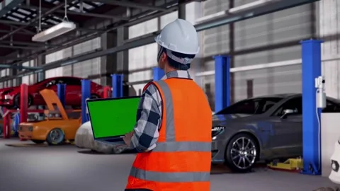 Engineer Working On A Green Screen Laptop in Auto Repair Shop Stock Footage 313531785