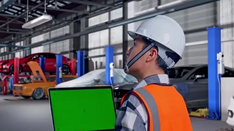 Engineer Working On A Green Screen Laptop in Auto Repair Shop Stock Footage 313533406