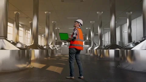Engineer Working On A Green Screen Laptop at Beer Plant Stock Footage 332546055