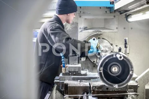 Engineer Working On Industrial Lathe In Engineering Factory