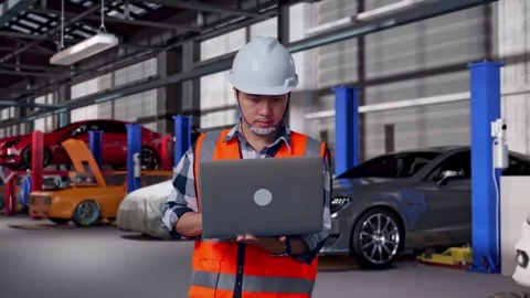 Engineer Working On A Laptop in Auto Repair Shop Stock Footage 313531404