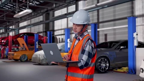 Engineer Working On A Laptop in Auto Repair Shop Stock Footage 313531644