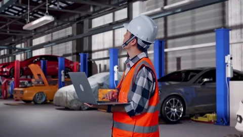 Engineer Working On A Laptop in Auto Repair Shop Stock Footage 313531661