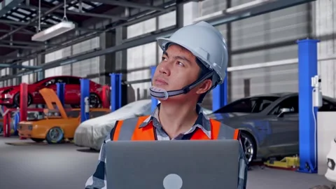Engineer Working On A Laptop in Auto Repair Shop Stock Footage 313532477