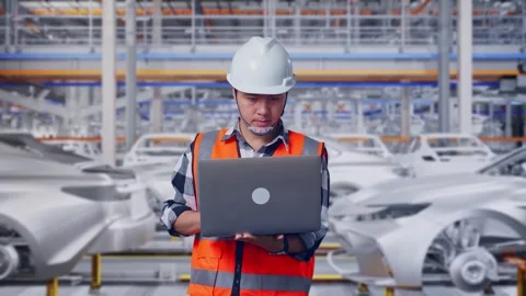 Engineer Working On A Laptop In Car Factory Stock Footage 331576746