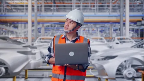 Engineer Working On A Laptop In Car Factory Stock Footage 331576778