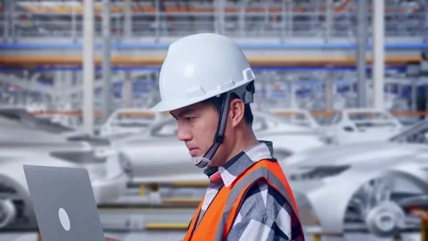 Engineer Working On A Laptop In Car Factory Stock Footage 331579194