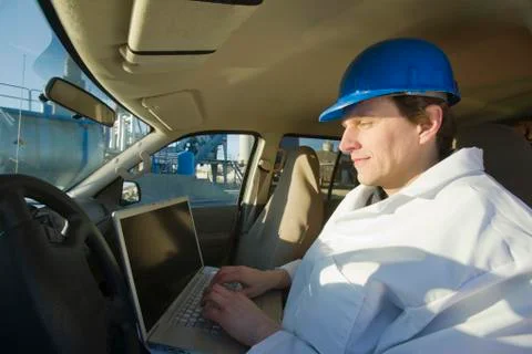Engineer working on a laptop in a car Stock Photos