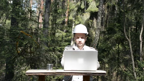 Engineer working on a laptop in the forest Stock Footage 131677458