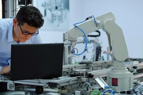 Engineer is working on laptop to programming smart factory automation Stock Photos