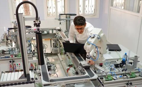 Engineer is working on laptop to programming smart factory automation Stock Photos