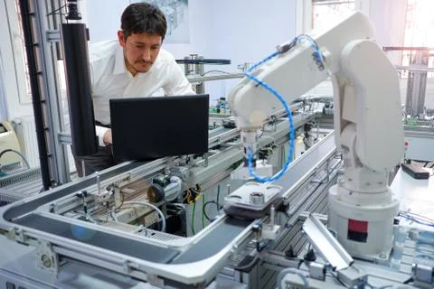 Engineer is working on laptop to programming smart factory automation Stock Photos