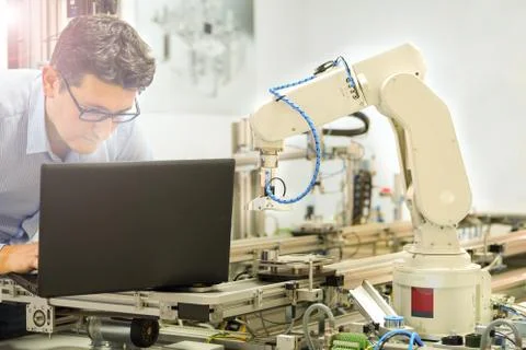 Engineer is working on laptop to programming smart factory automation Stock Photos