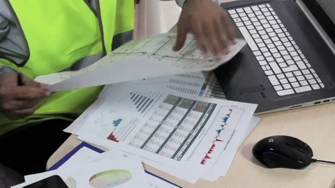 Engineer working office at desk, examining reports. Stock-Footage 75424257