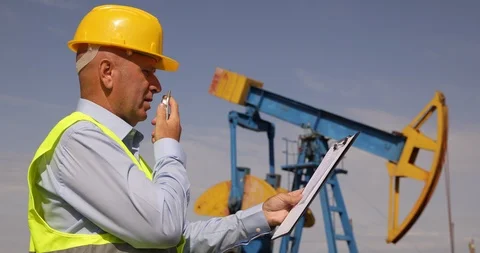 Engineer Working in Oil Extraction Industry Talk to a Handheld Transceiver Stock Footage 103262777