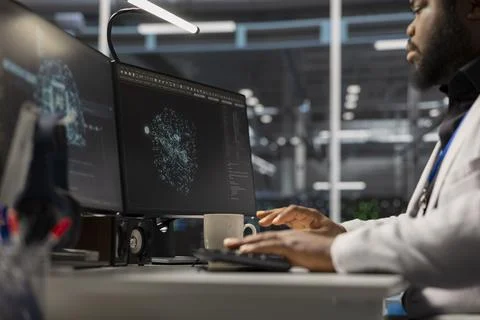 Engineer working on PC in data center housing artificial intelligence gear Stock Photos