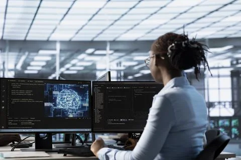 Engineer working at PC desk, doing checkup on AI server room 스톡 사진