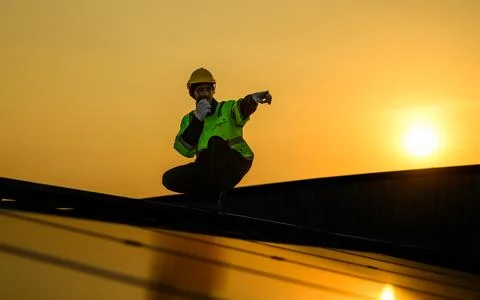 Engineer working at solar cell farm power plant with sunset in evening Foto stock