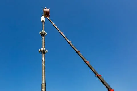 Engineer is working on the telecommunication tower - cellular phone repeater Stock Photos