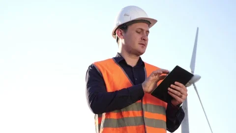 Engineer in working uniform of standing near the object and studies the tablet Stock Footage 124484919