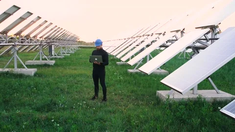 Engineer working using laptop stand next to solar batteries. Stock Footage 140203893