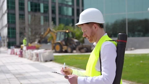 Engineer working writing notes in an urban construction site Stock Footage 274430752
