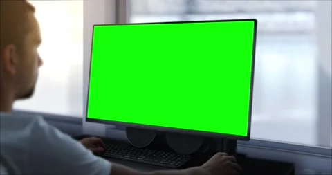 An engineer works on a computer with a green screen. In the background, the.. Stock-Footage 245219605