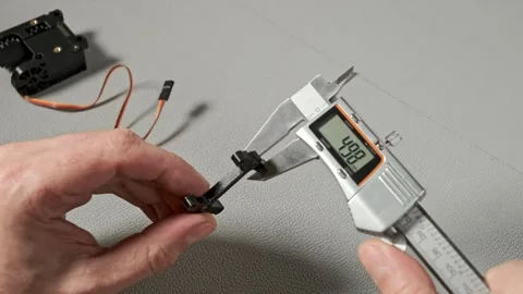An engineer works with a digital caliper to measure a small robotic servo c.. Stock Footage 340294944