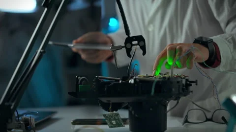 Engineer works on intricate robotic components in a laboratory setting durin Stock Footage 289571150