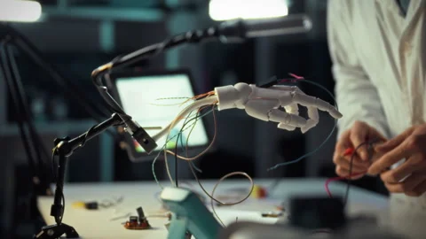 Engineer works on robotic hand in laboratory setting during evening hours Stock Footage 331304219