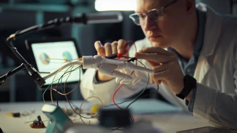 Engineer works on robotic hand prototype in advanced laboratory setting Stock Footage 331304220