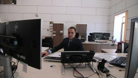 Engineer works at table with large monitors in control room Stock Footage 156319755
