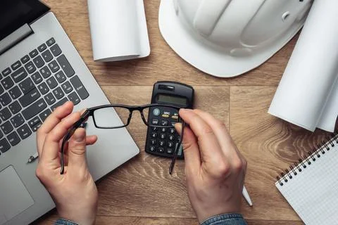 Engineer workspace. Men's hands hold glasses on the background of the workpla 写真素材