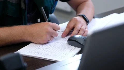 Engineer writes note put on register at table with laptop Stock Footage 158425205