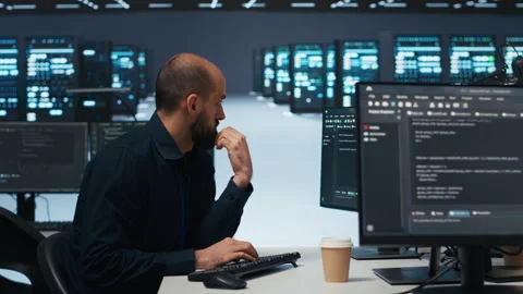 Engineer writing code in high tech facility with server rows Stock Footage 275500172