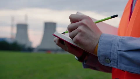 Engineer writing in a notebook against the background of a power plant Stock Footage 201669768