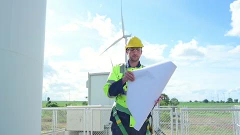 Engineer in a yellow helmet and reflective vest on the background Stock Footage 253986949