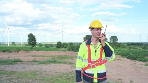 Engineer in a yellow helmet and reflective vest on the background Stock Footage 253998738