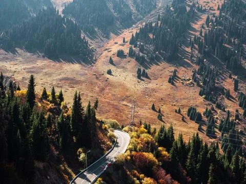 Engineered marvel: highway twisting along rugged mountain contours amid nature. Stock Photos