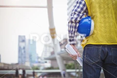 Engineering and construction concept. Closeup engineer with blueprint and hel Stock Photos