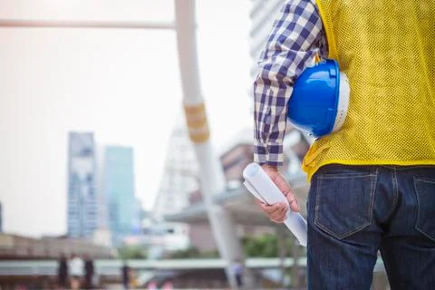 Engineering and construction concept. Closeup engineer with blueprint and hel Stock Photos
